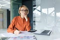 Portrait of young thinking business woman, blonde at workplace inside office concentrating and looking seriously at Royalty Free Stock Photo
