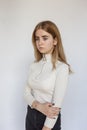 portrait of young thoughtful teen model wearing white sweater and black jeans Royalty Free Stock Photo