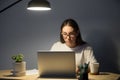 Portrait of young tired concentrated female office worker at nig