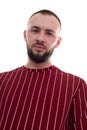 Portrait of young tranquil handsome bearded man with short dark hair wearing red striped sweatshirt, looking at camera. Royalty Free Stock Photo