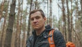 Portrait of young traveling man in woods. Close up of adult male in leather jacket with backpack in forest. Royalty Free Stock Photo