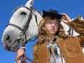 Portrait of young unhappy cowgirl with horse