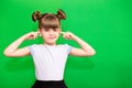 Portrait of young unhappy, stressed little girl covering her ears with fingers calling to stop noise isolated on green Royalty Free Stock Photo
