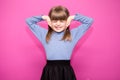 Portrait of young unhappy, stressed little girl covering her ears with hands calling to stop noise isolated on pink Royalty Free Stock Photo