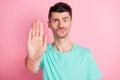 Portrait of young unhappy upset displeased dissatisfied man showing palm stop sign isolated on pink color background Royalty Free Stock Photo