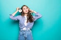 Portrait of young upset puzzled woman student in denim clothes hold alarm clock isolated on blue background. Time is running out. Royalty Free Stock Photo