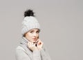 Portrait of a young and beautiful woman in a winter hat over grey background. Royalty Free Stock Photo