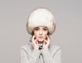 Portrait of a young and beautiful woman in a winter hat over grey background. Royalty Free Stock Photo