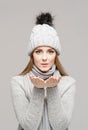 Portrait of a young and beautiful woman in a winter hat over grey background. Royalty Free Stock Photo