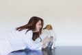 Portrait of a young veterinarian woman examining a cute small dog by using stethoscope, isolated on white background. Indoors Royalty Free Stock Photo