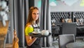 Portrait young waitress standing in cafe. girl the waiter holds in bunches a tray with utensils Royalty Free Stock Photo