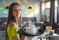 Portrait young waitress standing in cafe. girl the waiter holds in bunches a tray with utensils Royalty Free Stock Photo