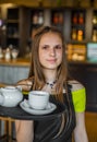 Portrait young waitress standing in cafe. girl the waiter holds in bunches a tray with utensils Royalty Free Stock Photo