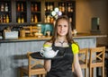 Portrait young waitress standing in cafe. girl the waiter holds in bunches a tray with utensils Royalty Free Stock Photo