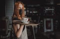 Young waitress standing in cafe. girl the waiter holds in bunches a tray with utensils. Restaurant service Royalty Free Stock Photo