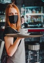 Young waitress standing in cafe. girl the waiter holds in bunches a tray with utensils. Restaurant service Royalty Free Stock Photo