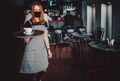 Young waitress standing in cafe. girl the waiter holds in bunches a tray with utensils. Restaurant service Royalty Free Stock Photo