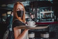 Young waitress standing in cafe. girl the waiter holds in bunches a tray with utensils. Restaurant service Royalty Free Stock Photo
