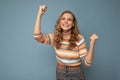 Portrait of young winsome attractive happy smiling blonde woman with wavy-hair wearing striped sweater isolated over Royalty Free Stock Photo