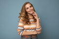 Portrait of young winsome attractive happy smiling blonde woman with wavy-hair wearing striped sweater isolated over Royalty Free Stock Photo