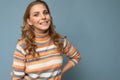 Portrait of young winsome attractive happy smiling blonde woman with wavy-hair wearing striped sweater isolated over Royalty Free Stock Photo