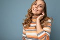 Portrait of young winsome attractive happy smiling blonde woman with wavy-hair wearing striped sweater isolated over Royalty Free Stock Photo