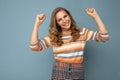 Portrait of young winsome attractive happy smiling blonde woman with wavy-hair wearing striped sweater isolated over Royalty Free Stock Photo