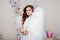 Portrait of a young woman, an angel in a white dress stands wrapped in wings Royalty Free Stock Photo