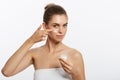 Portrait of young woman applying moisturizer cream on her pretty face. Isolated on white background Royalty Free Stock Photo