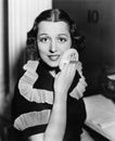 Portrait of a young woman applying powder to her face