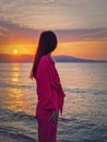 Portrait of a young woman as meets the dawn at the sea. Beautiful sunrise at the Bulgarian coastline of Black Sea, Sunny beach Royalty Free Stock Photo