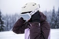 Young woman athlete puts on a helmet and goggles for skiing. portrait of a man in sports equipment for snowboarding Royalty Free Stock Photo