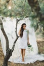 Portrait of young woman on background of white hanging textile cloth in garden Royalty Free Stock Photo