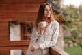 Portrait of young woman on the balcony holding a cup of coffee or tea in the morning Royalty Free Stock Photo