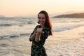 Portrait of a young woman on the beach at red sunset, beckons with you, calling to have fun Royalty Free Stock Photo