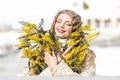 Portrait of a young woman with blond hair holding a bouquet of mimosa in her hands. Spring Royalty Free Stock Photo