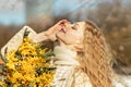 Portrait of a young woman with blond hair holding a bouquet of mimosa in her hands. Spring Royalty Free Stock Photo