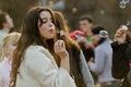 Portrait of young woman blowing soap bubbles on a flashmob in Volgograd