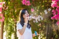 Happy beautiful young woman blowing soap bubbles outdoor. Royalty Free Stock Photo