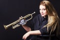 Portrait of young woman blowing on the trumpet isolated on black background Royalty Free Stock Photo