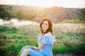 Portrait of young woman in blue romantic dress and straw hat in sun light enjoying summer sunset on nature. Calm and harmony. Royalty Free Stock Photo