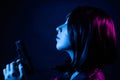 Portrait of a young woman with a bob hairstyle in a black leather jacket and a spiked collar with a gun in her hands Royalty Free Stock Photo