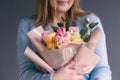 Portrait of a young woman with a bouquet of roses on a gray background. Royalty Free Stock Photo