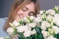 Portrait of a young woman with a bouquet of roses on a gray background. Royalty Free Stock Photo