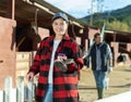 Portrait of young woman with brushes in her hands for cleaning and caring for horses at horse farm