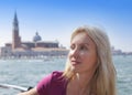 Portrait of the young woman on Canal Grande and Bell tower of Basilica backgraund. Venice, Italy