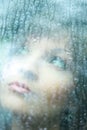 Attractive woman looking out of the window on rainy day Royalty Free Stock Photo