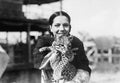 Portrait of a young woman carrying a cheetah cub and smiling Royalty Free Stock Photo