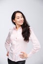 Portrait of a young woman with a charming toothy smile, black hair and brown eyes on a white background in a pink shirt. Positive Royalty Free Stock Photo