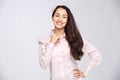 Portrait of a young woman with a charming toothy smile, black hair and brown eyes on a white background in a pink shirt. Positive Royalty Free Stock Photo